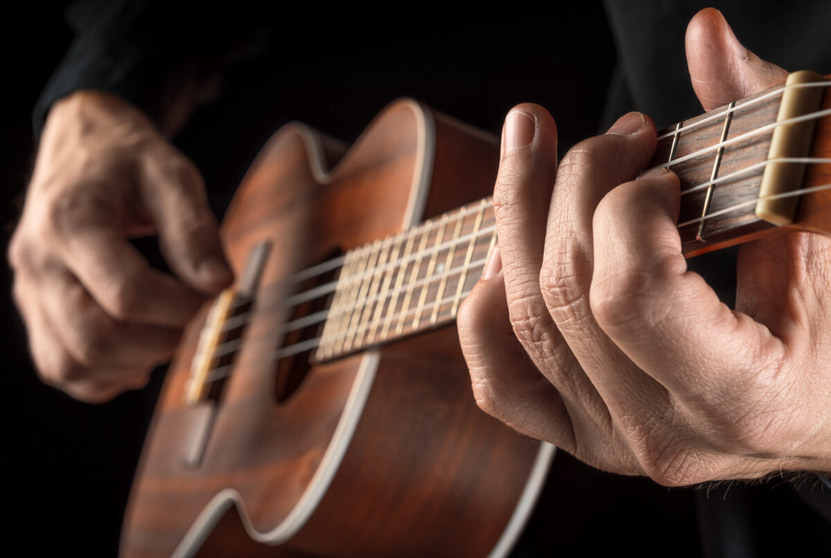 hands paying a tenor ukulele to learn ukulele